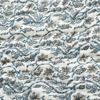 Floral and vine patterned fabric in blue and green on a white background