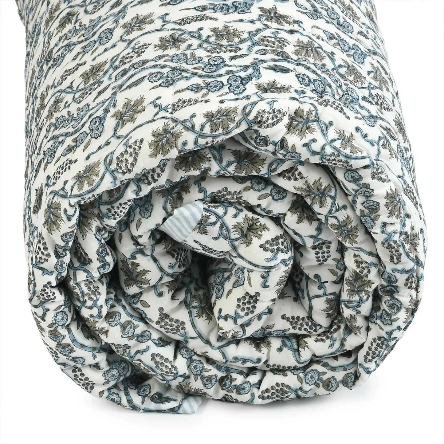 Rolled-up floral-patterned quilt on a white background