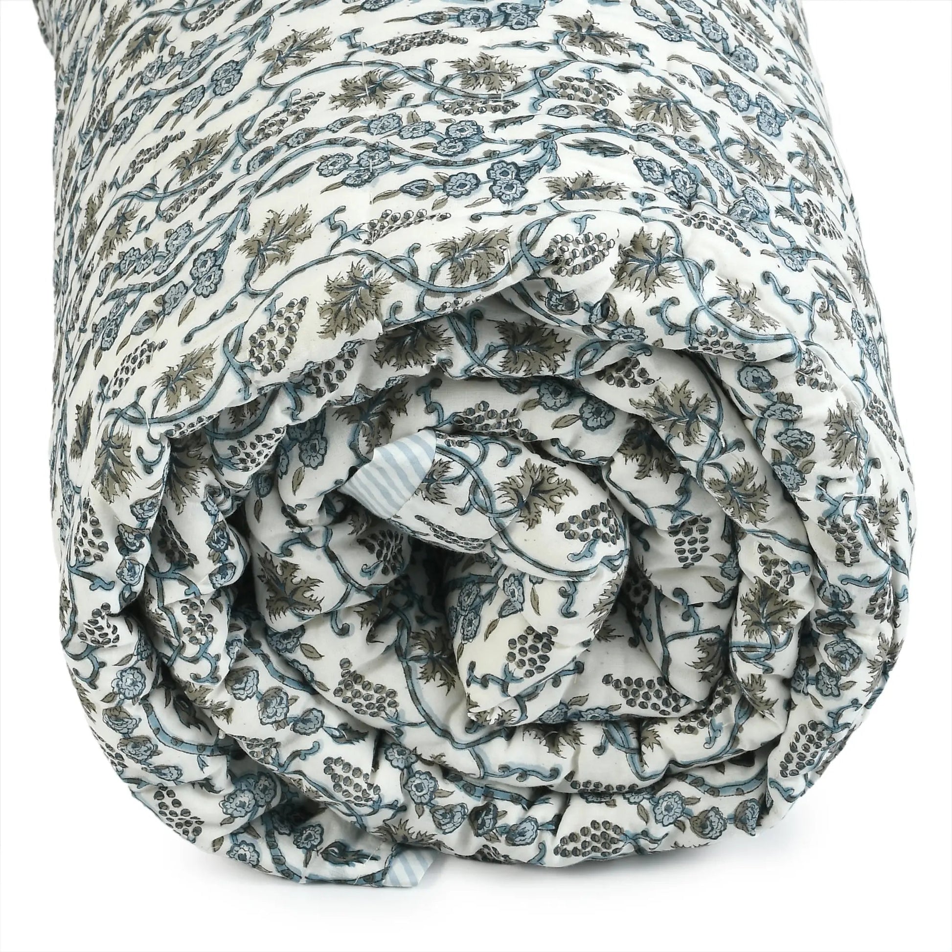 Rolled-up floral-patterned quilt on a white background