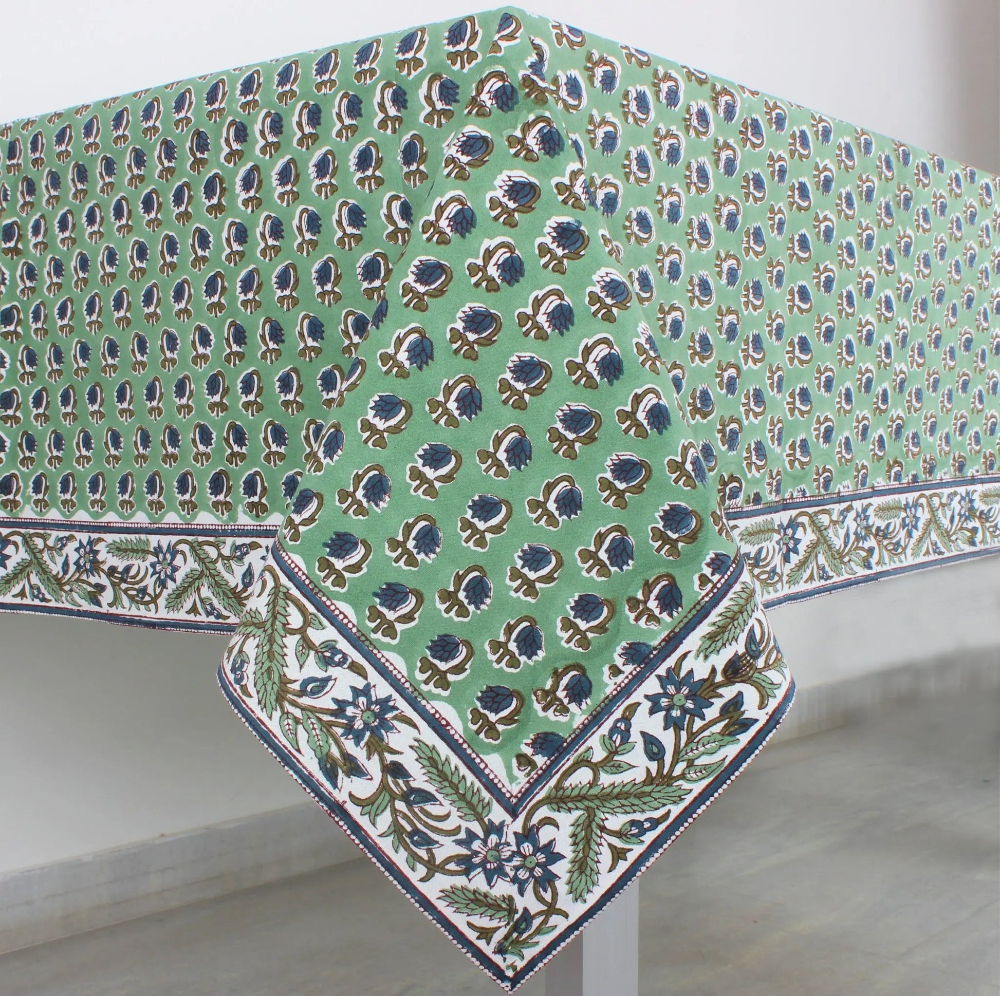 Green floral patterned tablecloth on a white surface
