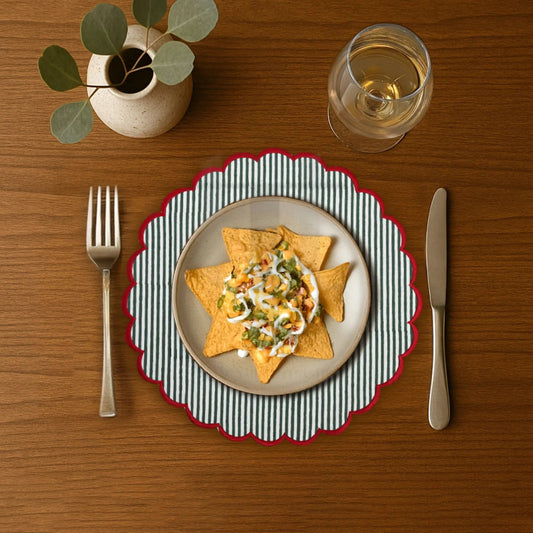 Dinner setting with a plate of food, fork, knife, and glass on a wooden table.