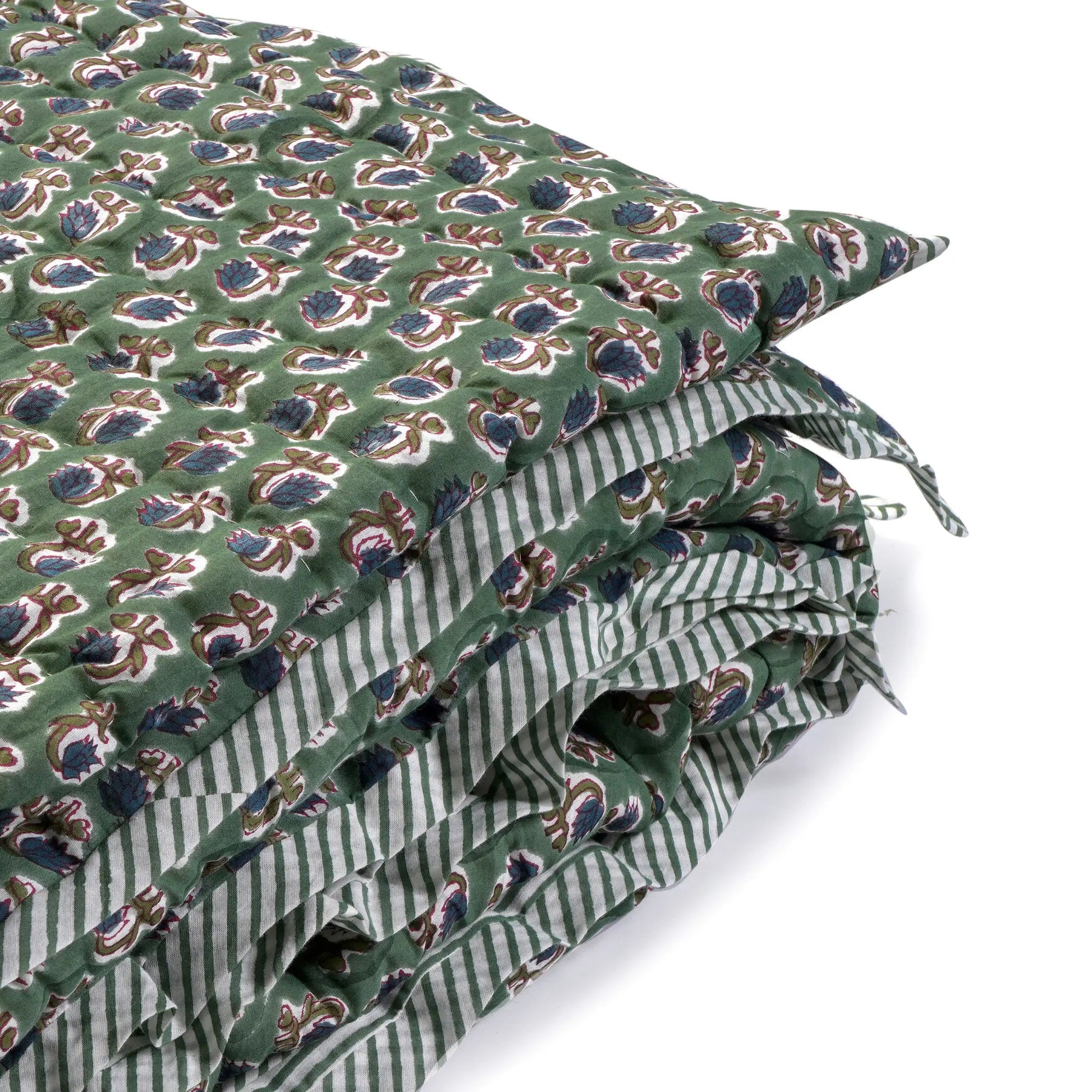 Green fabric with a pattern of blue and white shapes on a white background