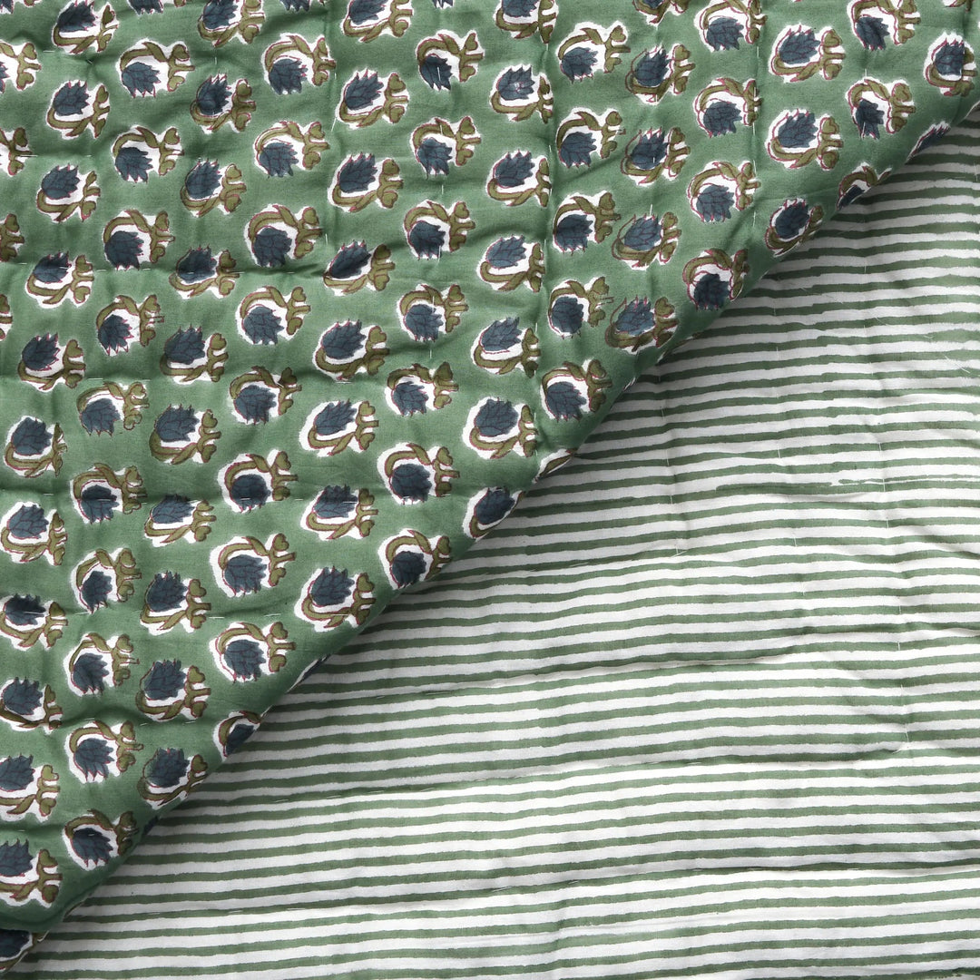 Close-up of green patterned fabric with a striped fabric underneath