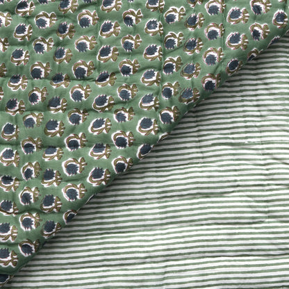 Close-up of green patterned fabric with a striped fabric underneath