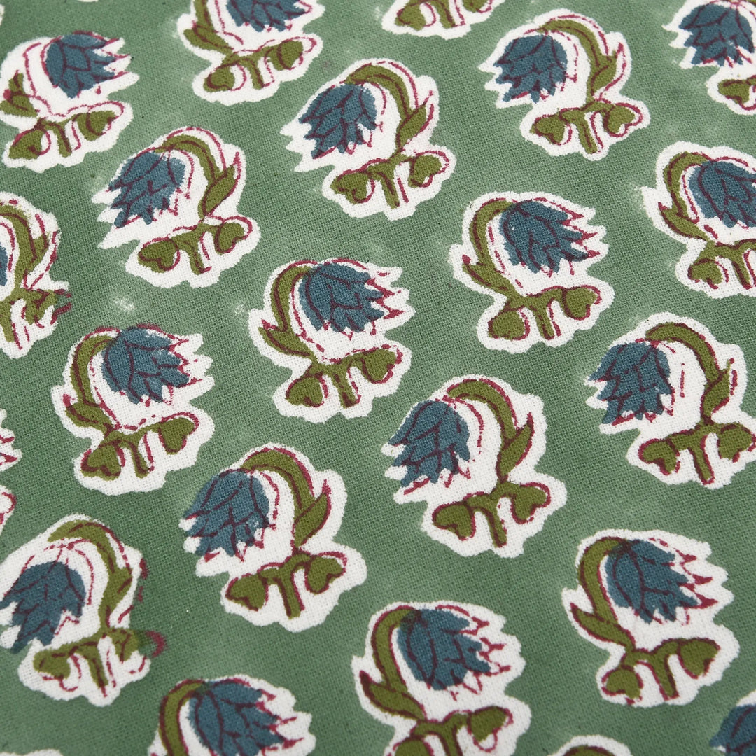 Patterned fabric with blue and green floral design on a green background