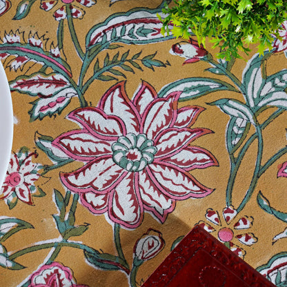 Close-up of a floral patterned fabric with pink and white flowers on a beige background.