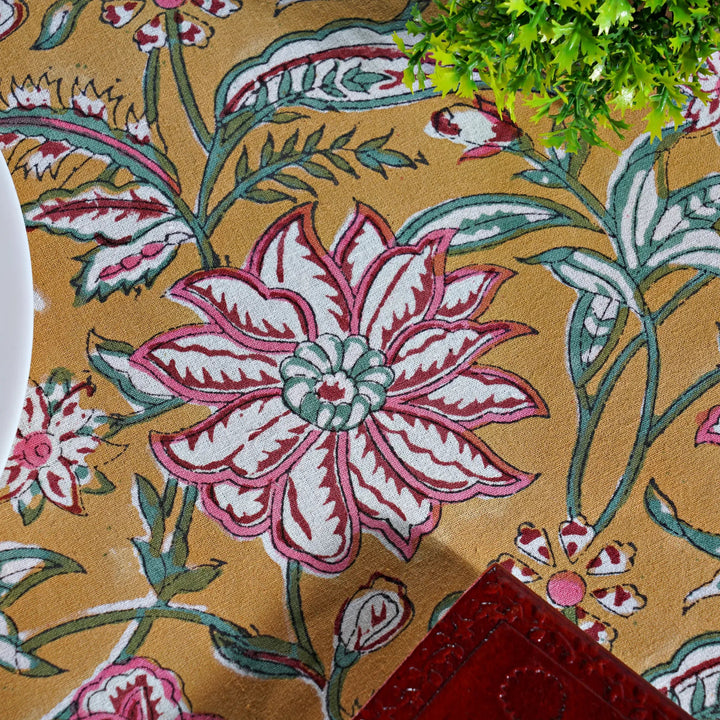 Close-up of a floral patterned fabric with pink and white flowers on a beige background.