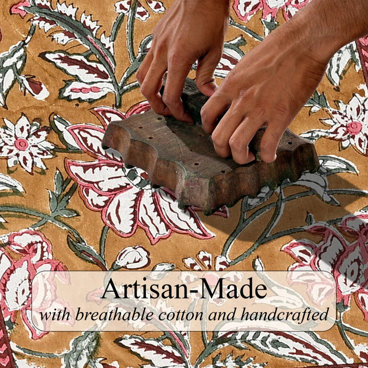 Hand using a wooden block to print a floral pattern on fabric with &