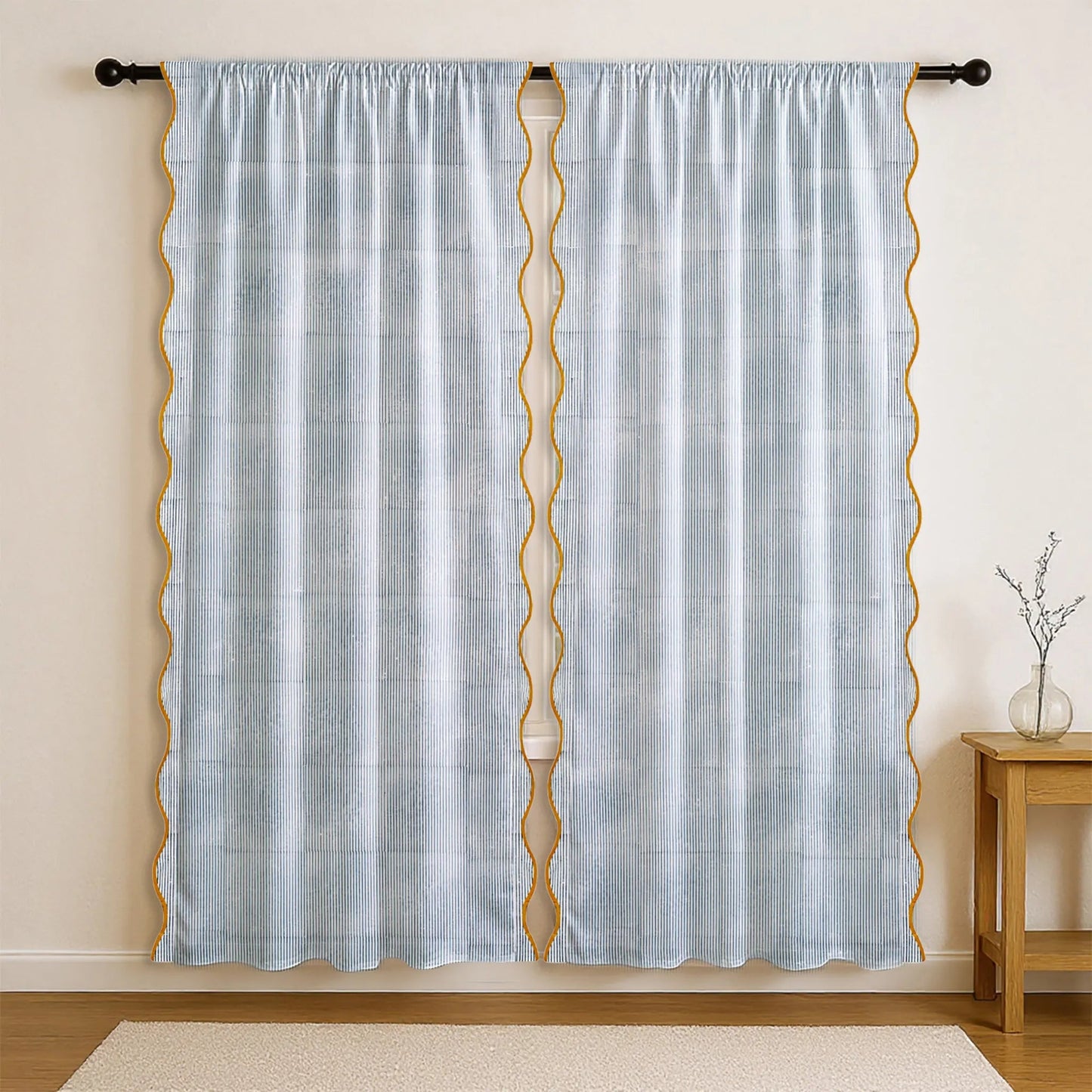 Light blue curtain with gold geometric patterns on a beige wall.
