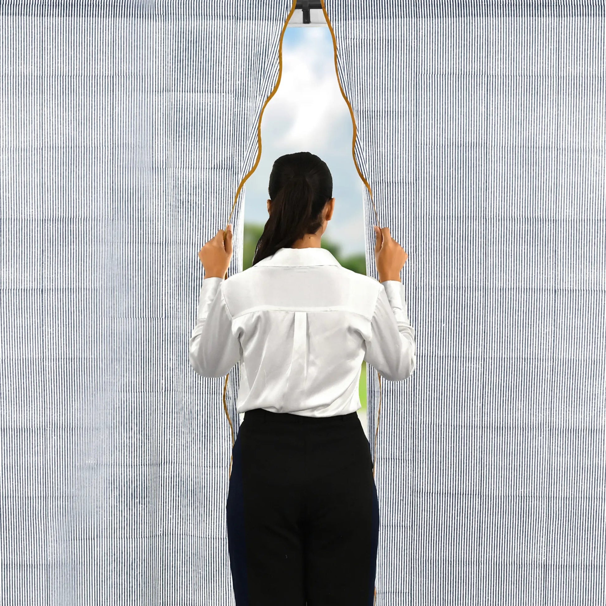 Person holding a unique mirror with a geometric design against a textured wall.