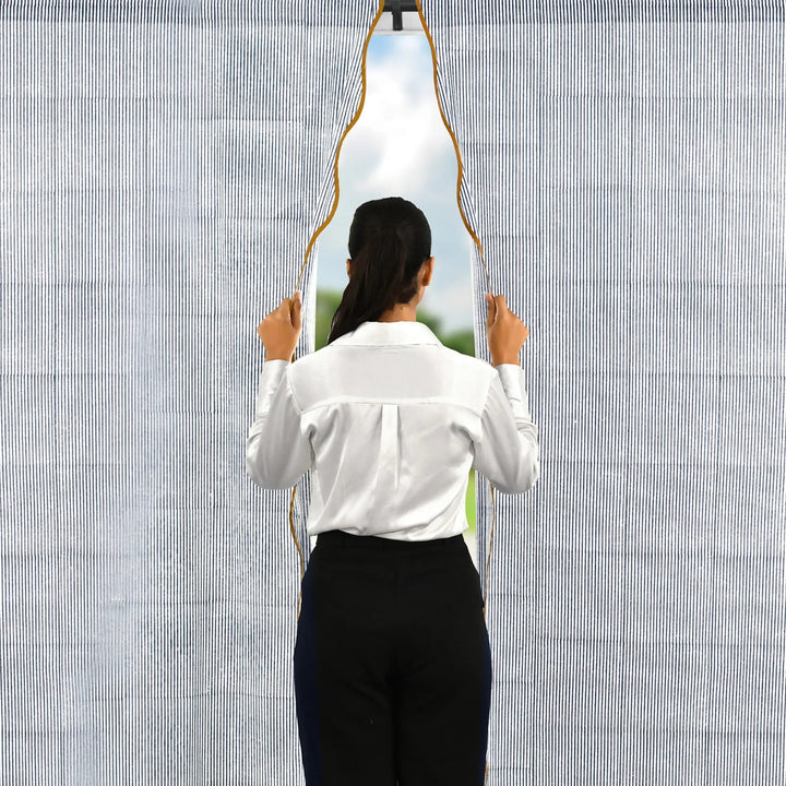 Person holding a unique mirror with a geometric design against a textured wall.