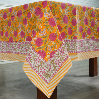Colorful floral-patterned tablecloth on a wooden table with a white background