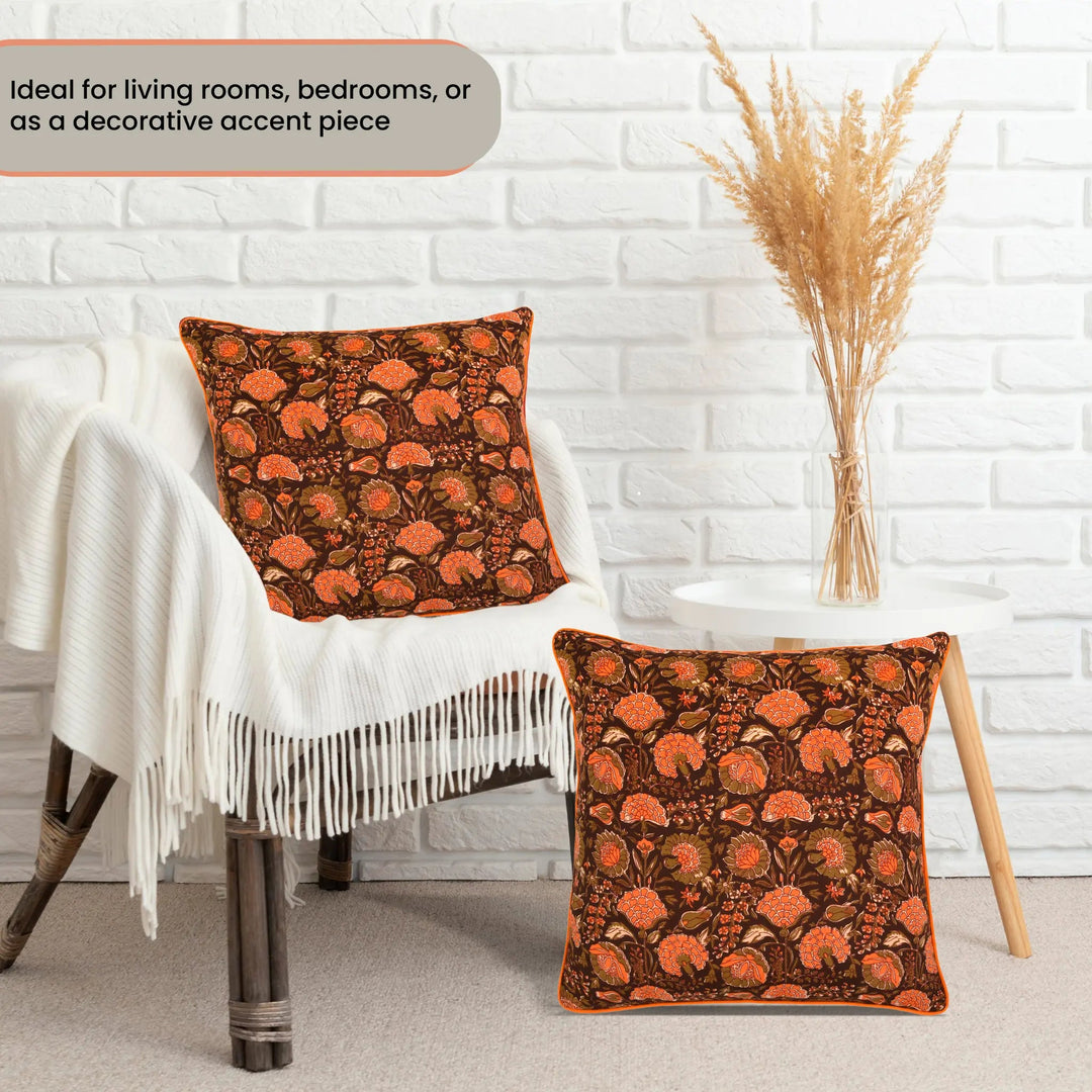 Decorative pillows with floral pattern on a chair against a white brick wall.