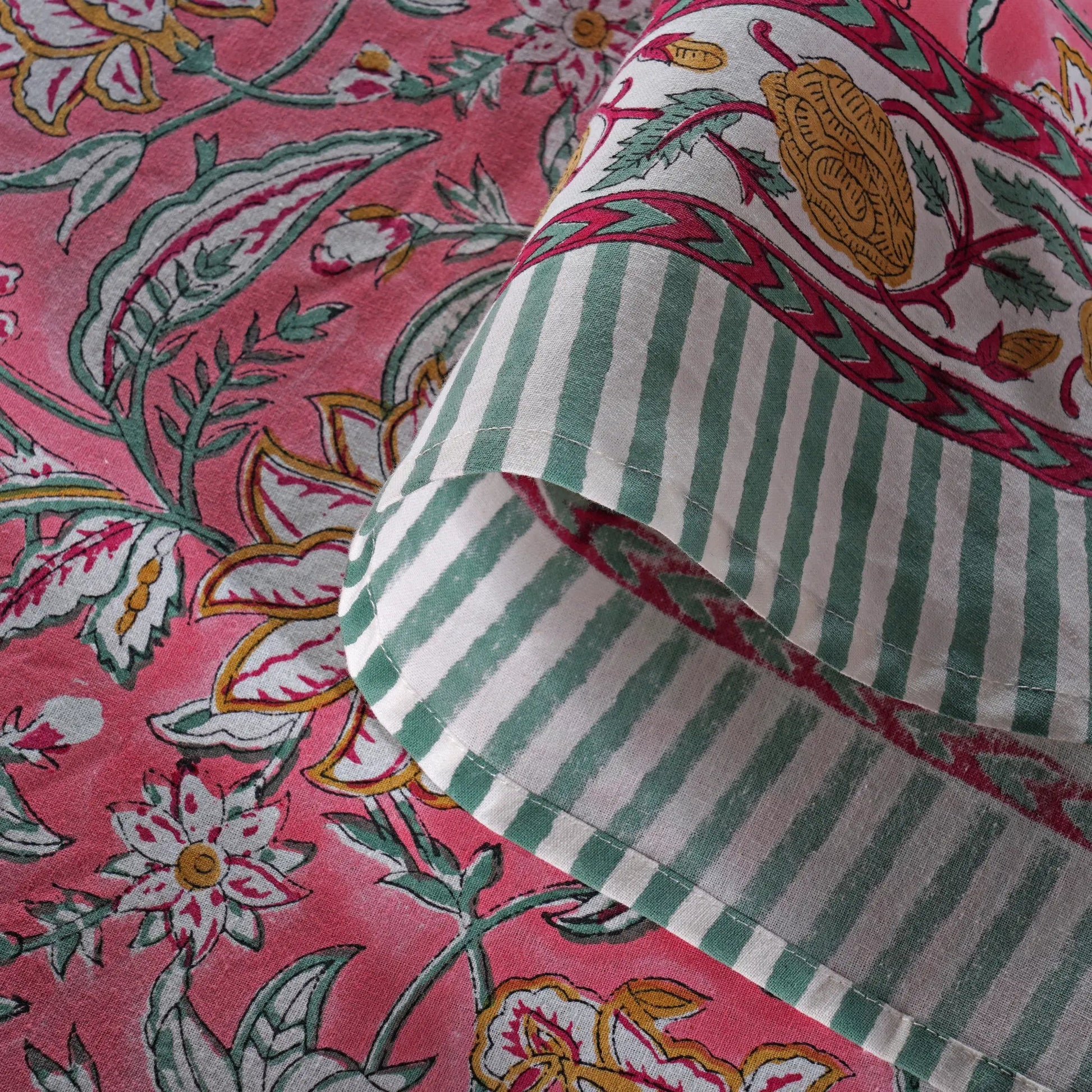 Close-up of fabric with pink floral and green striped patterns