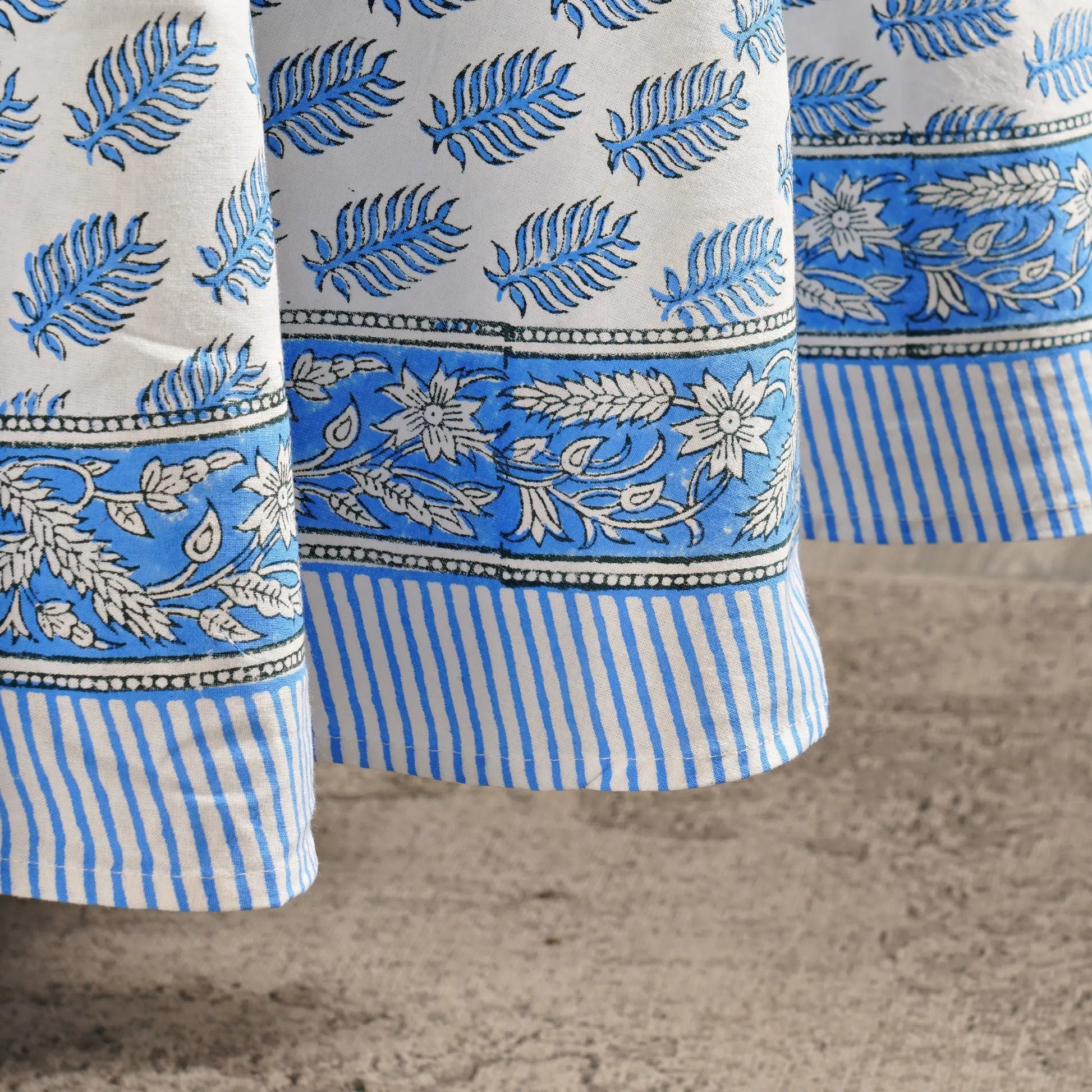 Close-up of blue and white patterned fabric on a textured surface