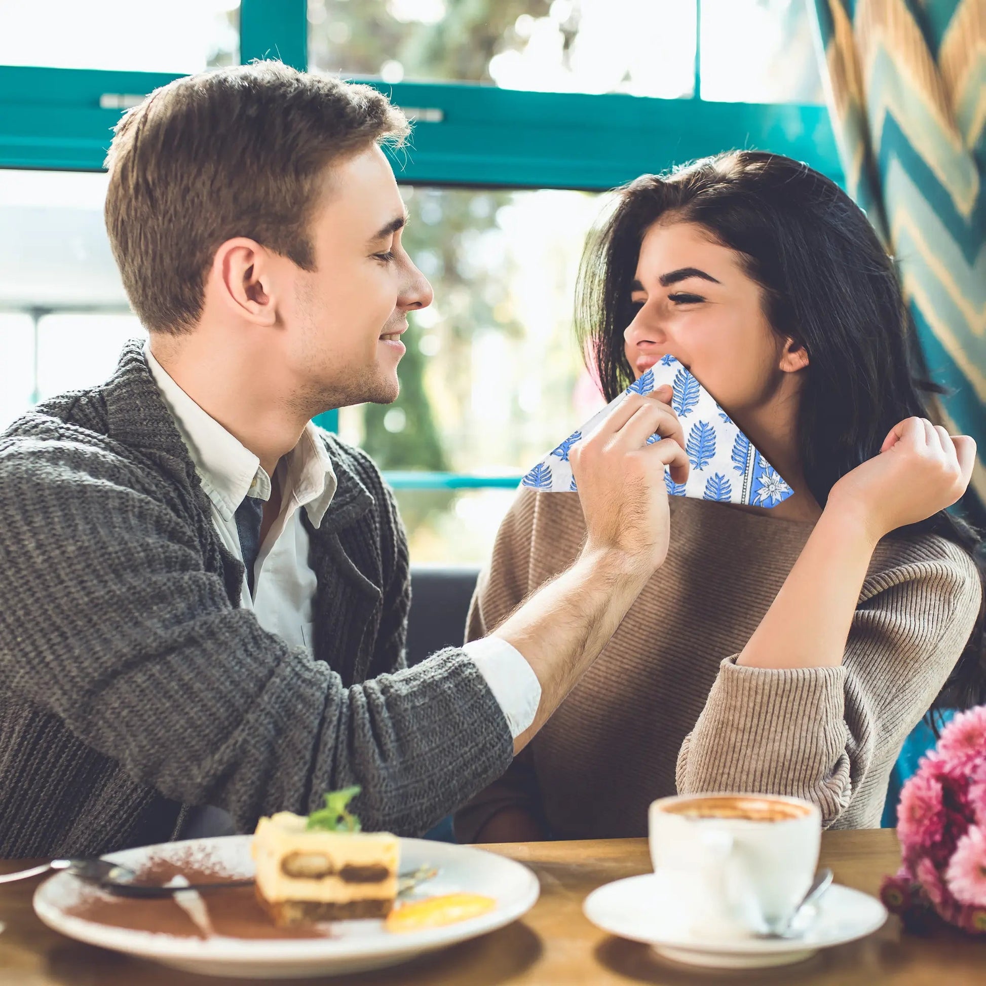 Man and woman sharing a piece of cake in a cafe