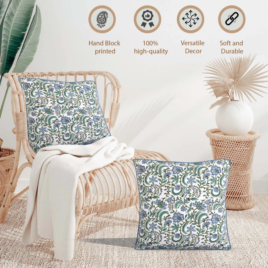Decorative pillows with floral patterns on a wicker chair, surrounded by plants and decor items.