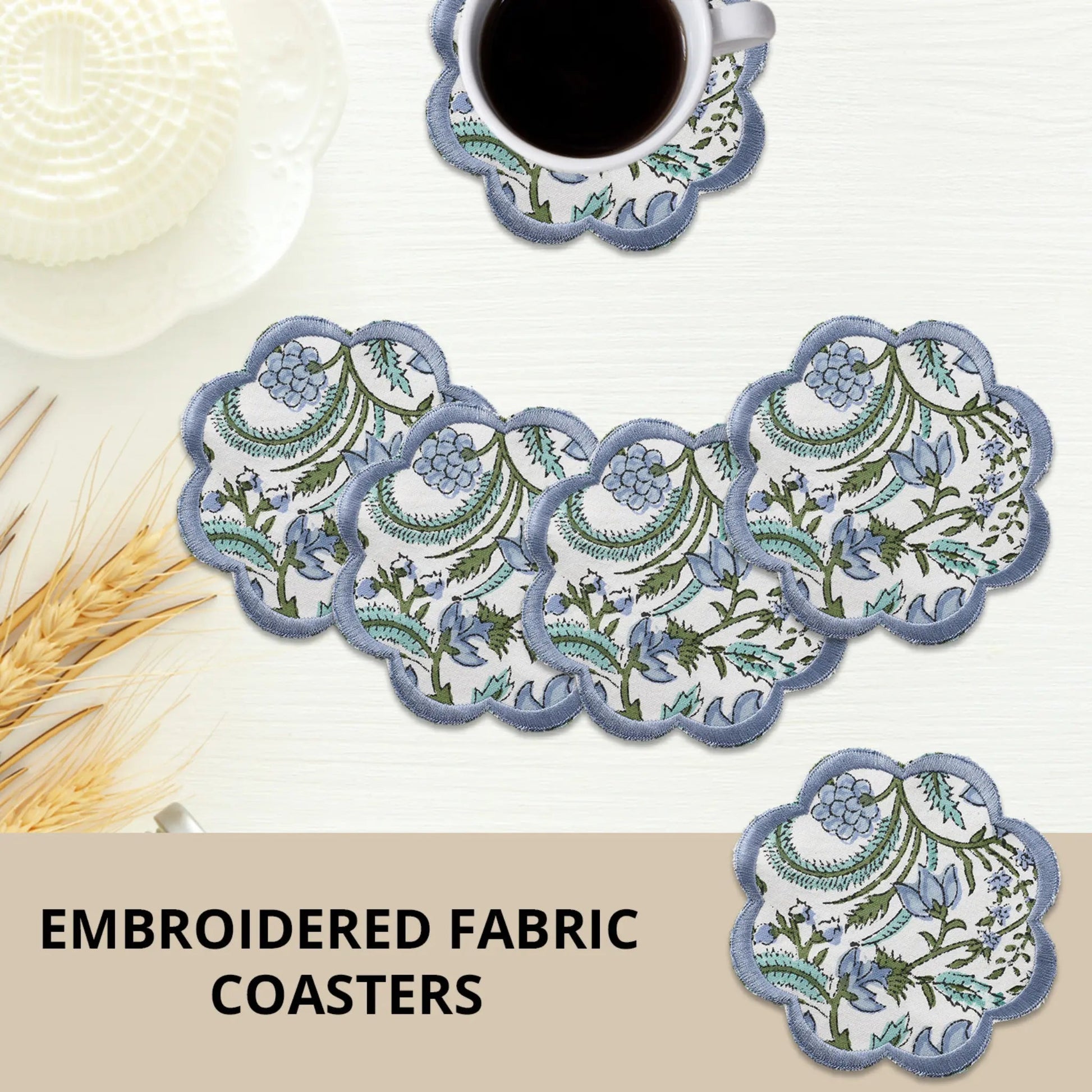 Set of embroidered fabric coasters with a cup of coffee on a white surface.