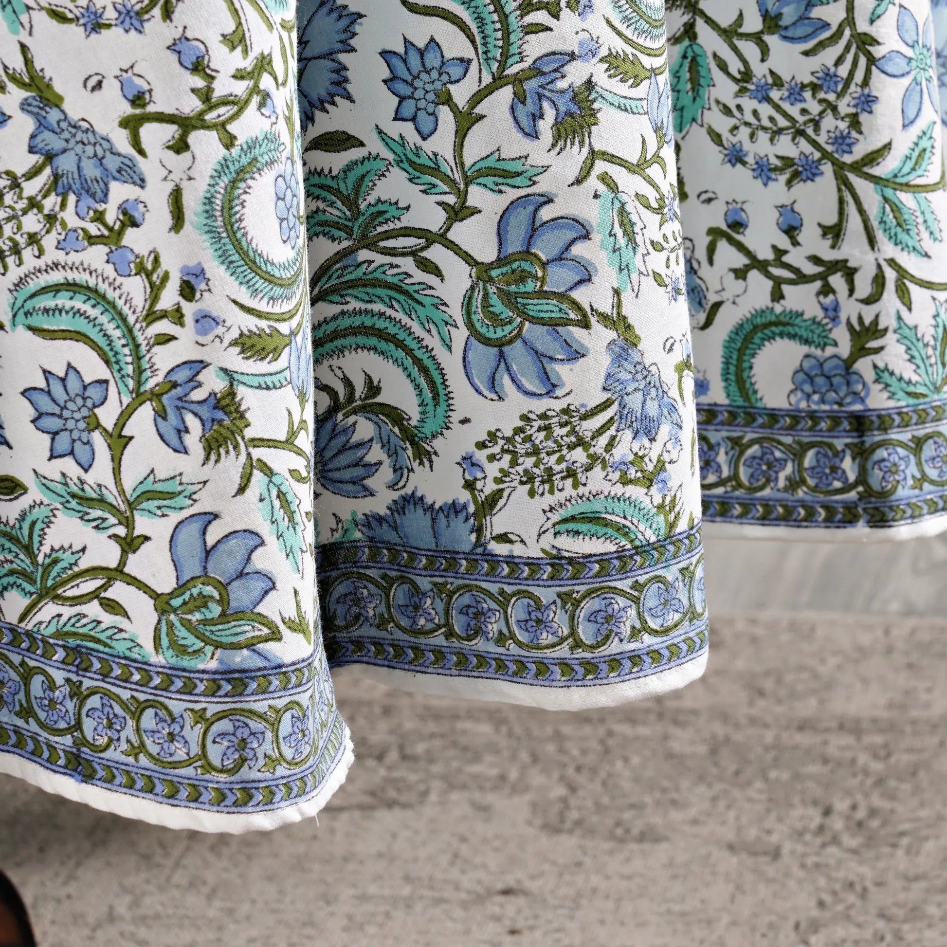Close-up of floral patterned fabric with blue and green colors on a neutral background