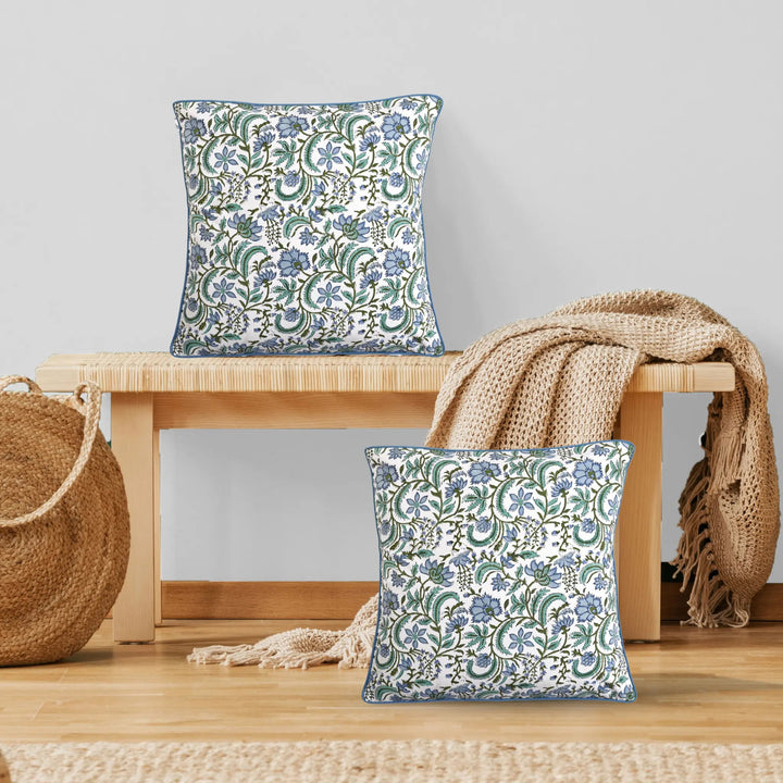 Floral patterned cushions on a wooden bench with a neutral background