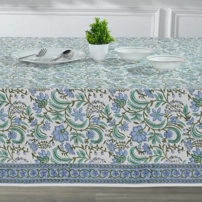 Decorative tablecloth with floral pattern on a set dining table.