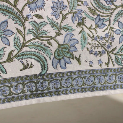 Close-up of floral and leaf patterned fabric with blue and green colors.