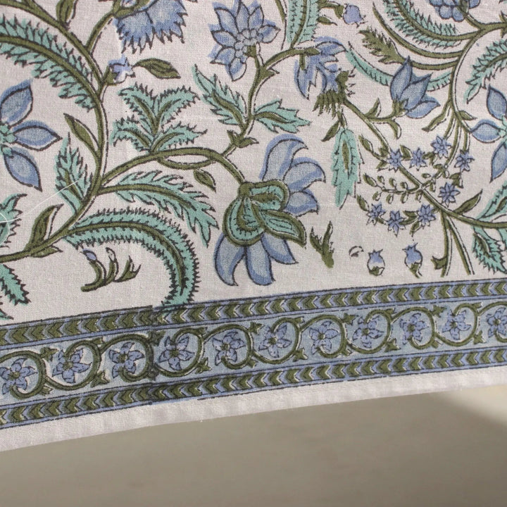 Close-up of floral and leaf patterned fabric with blue and green colors.
