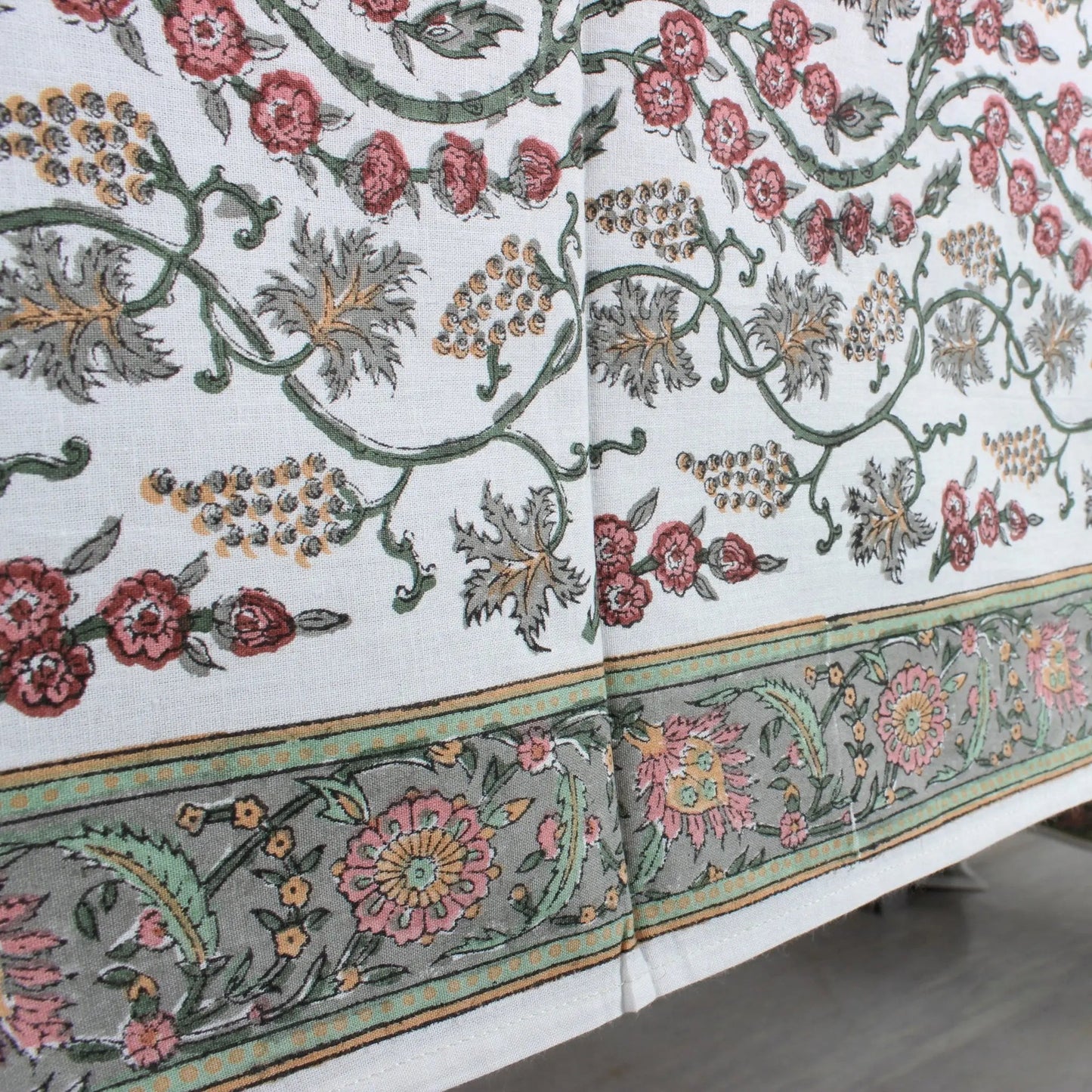Decorative tablecloth with floral and leaf patterns on a white background