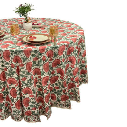 Round table with a floral patterned tablecloth on a white background