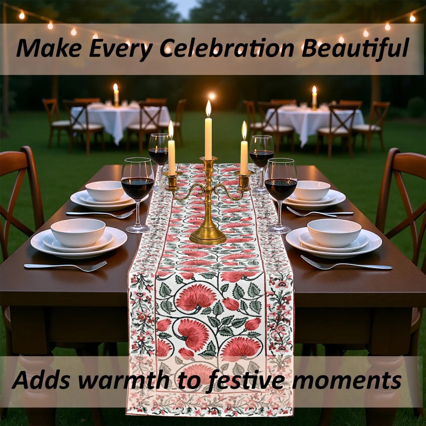 Dining table set with floral table runner, candles, and wine glasses outdoors.