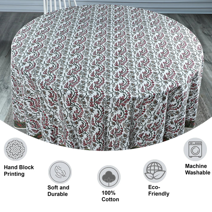 Round tablecloth with floral pattern on a wooden floor, featuring icons and text about material and care.