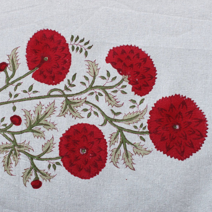 Embroidered design of red flowers and green leaves on a white fabric background