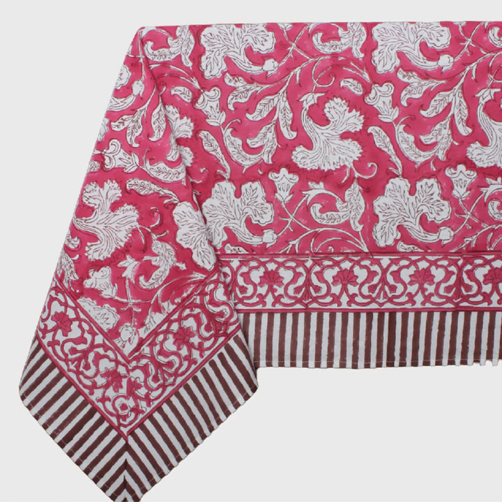 Pink tablecloth with white floral pattern on a white background