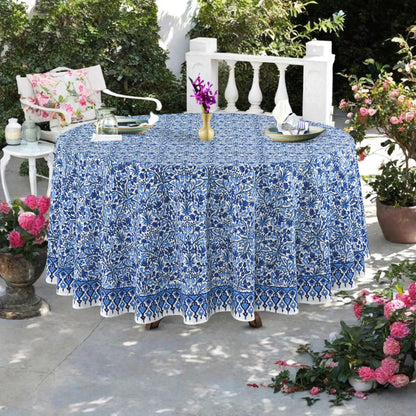 Round table with a blue floral tablecloth outdoors on a patio