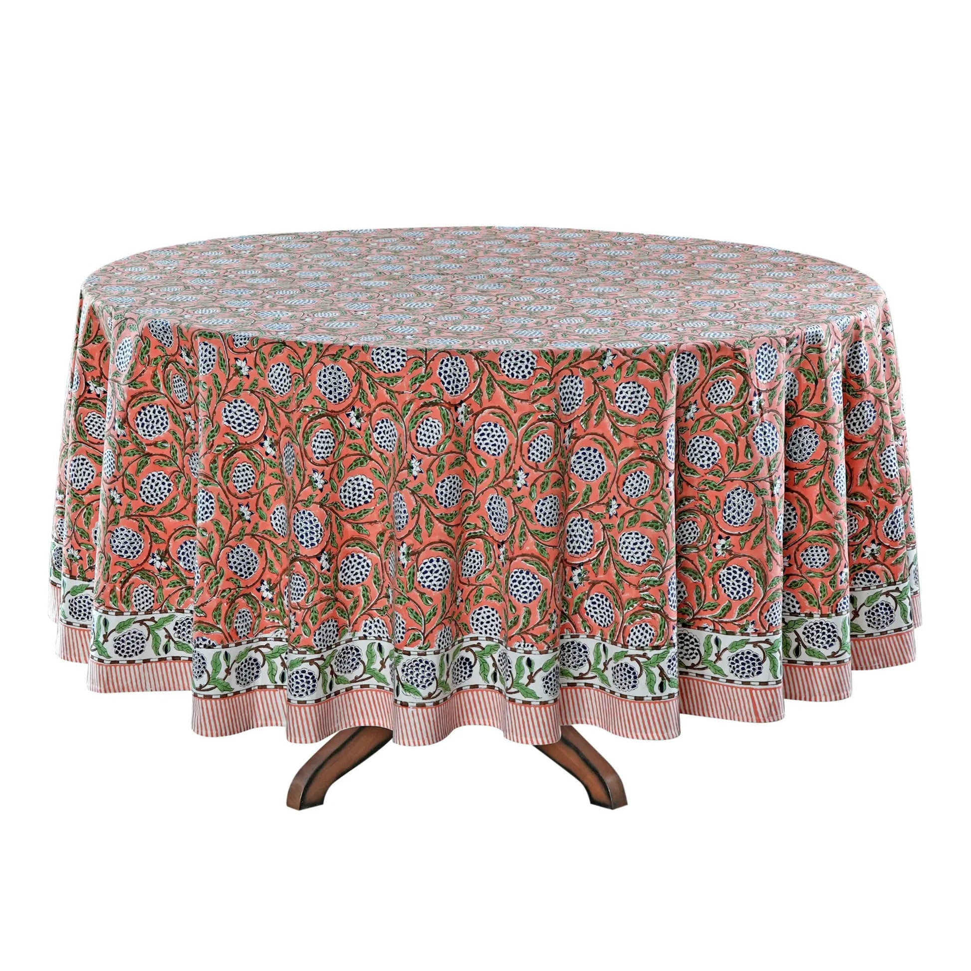 Round table with a floral patterned tablecloth on a white background