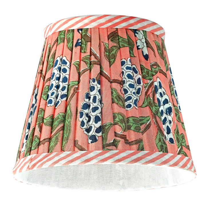 Floral patterned lampshade with striped base on a white background