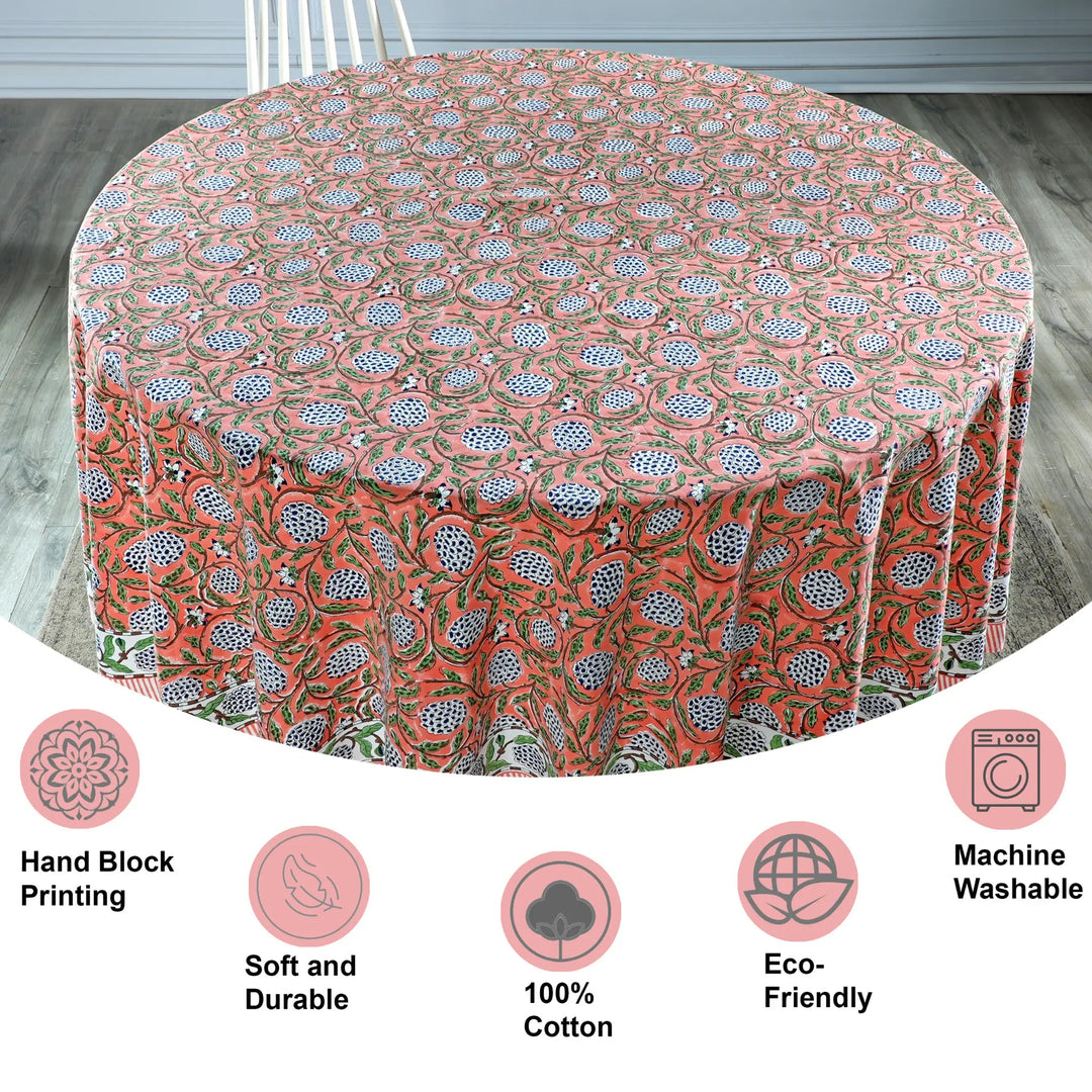 Round tablecloth with floral pattern on a wooden floor, featuring icons and text about material and care.