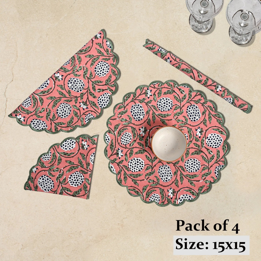 Set of pink and green patterned placemats and coasters on a beige background