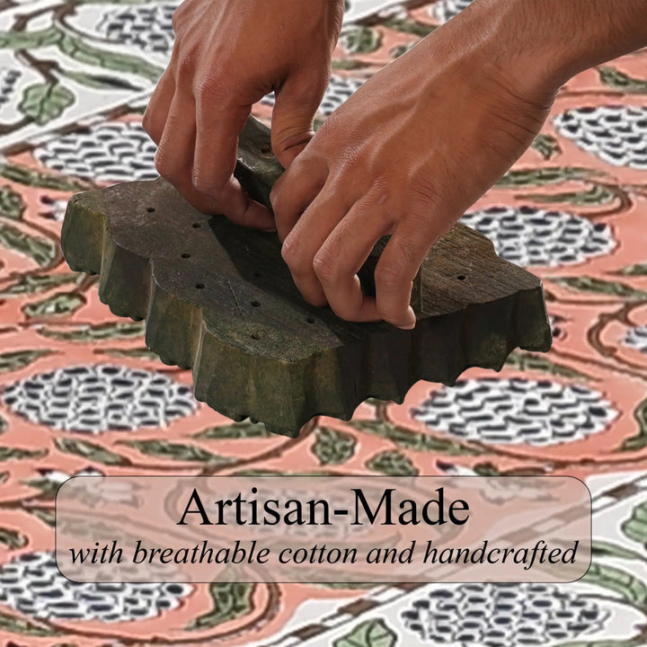 Hands using a traditional stamp on fabric with &