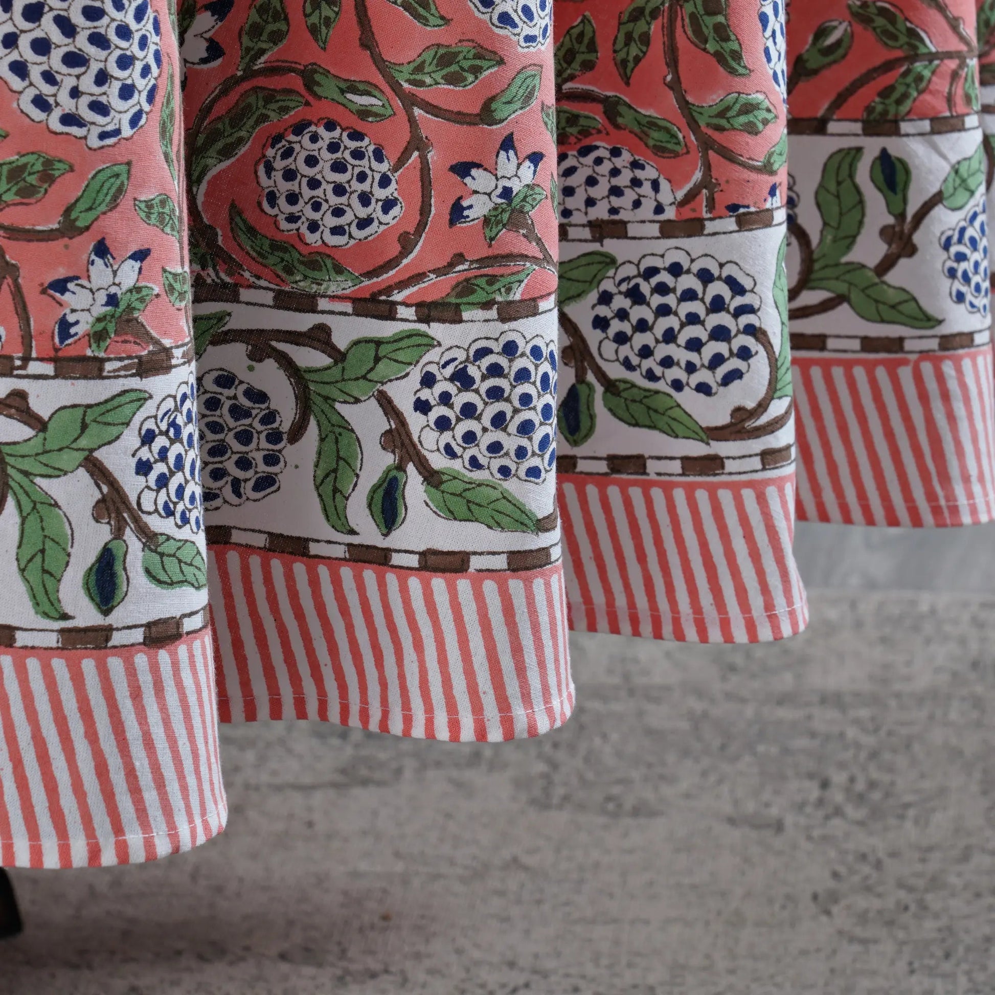 Close-up of patterned fabric with floral and striped designs on a neutral background