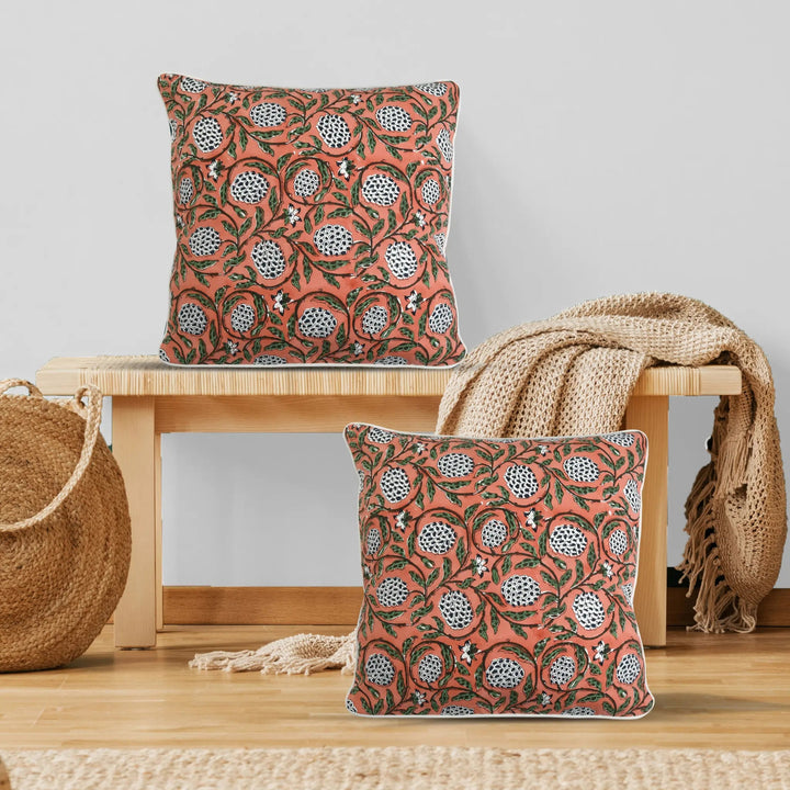 Decorative pillows with a floral pattern on a wooden bench and surface.