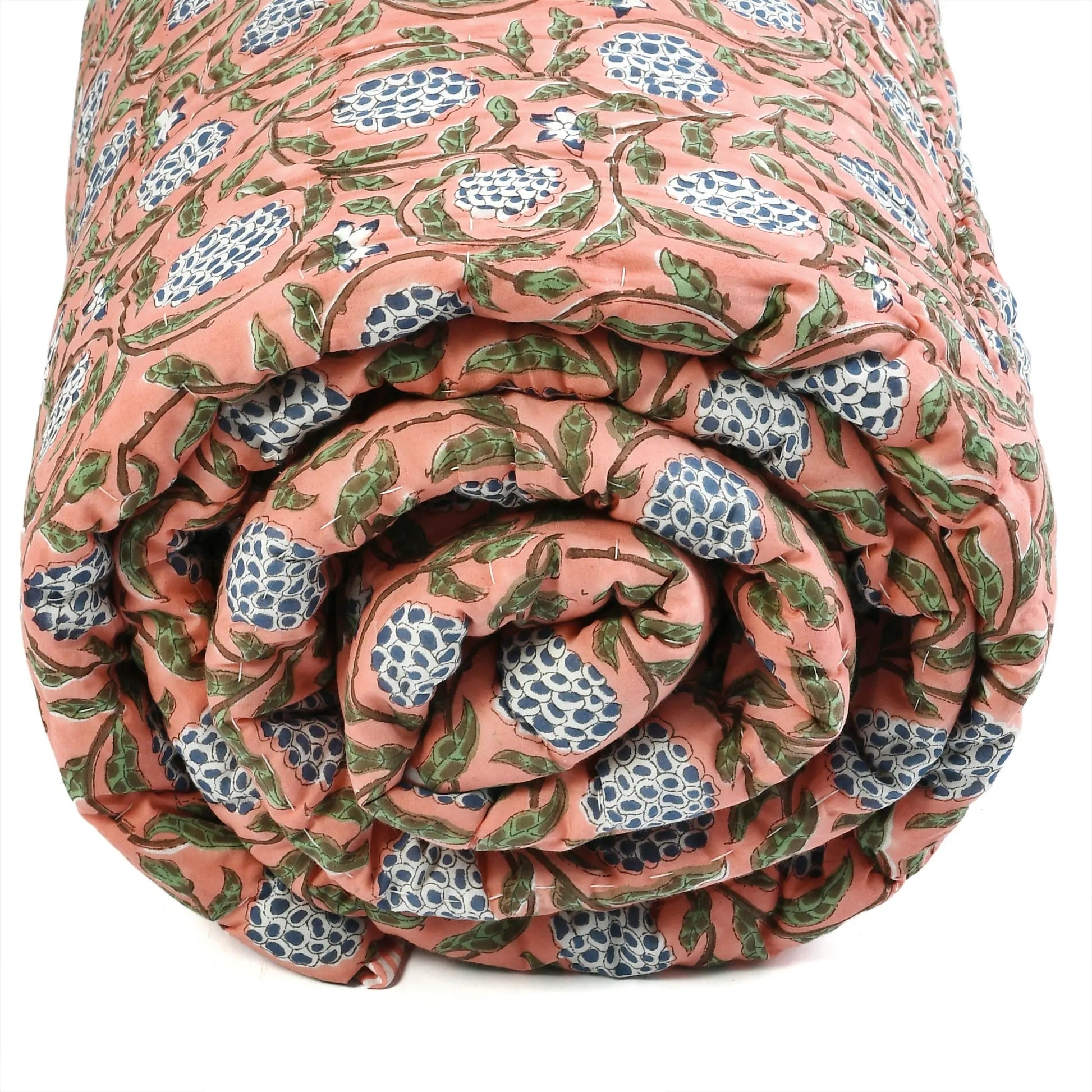 Rolled-up floral-patterned quilt on a white background