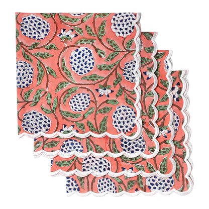 Set of three floral patterned napkins with scalloped edges on a white background