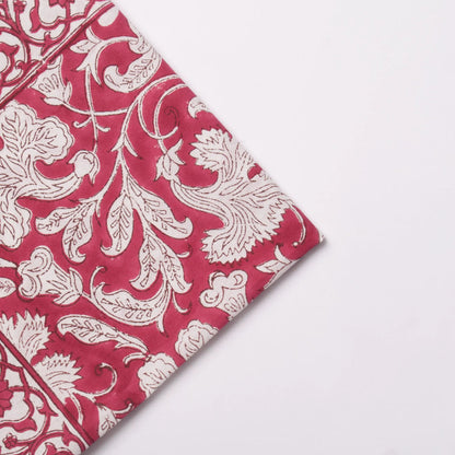Red fabric with white floral patterns on a light gray background