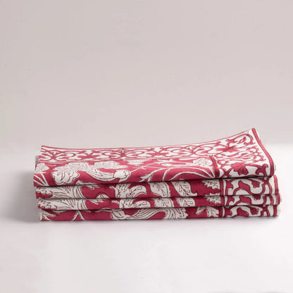 Stack of red and white patterned napkins on a light gray background