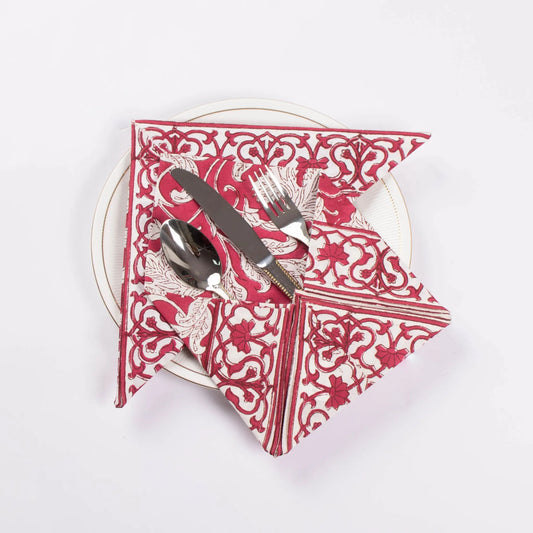 Red and white patterned napkin with silver cutlery on a white background