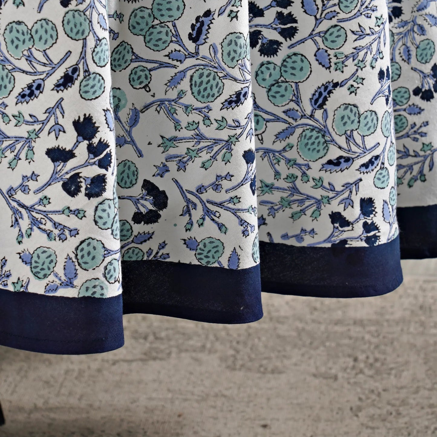 Close-up of a fabric with blue and green floral pattern on a white background