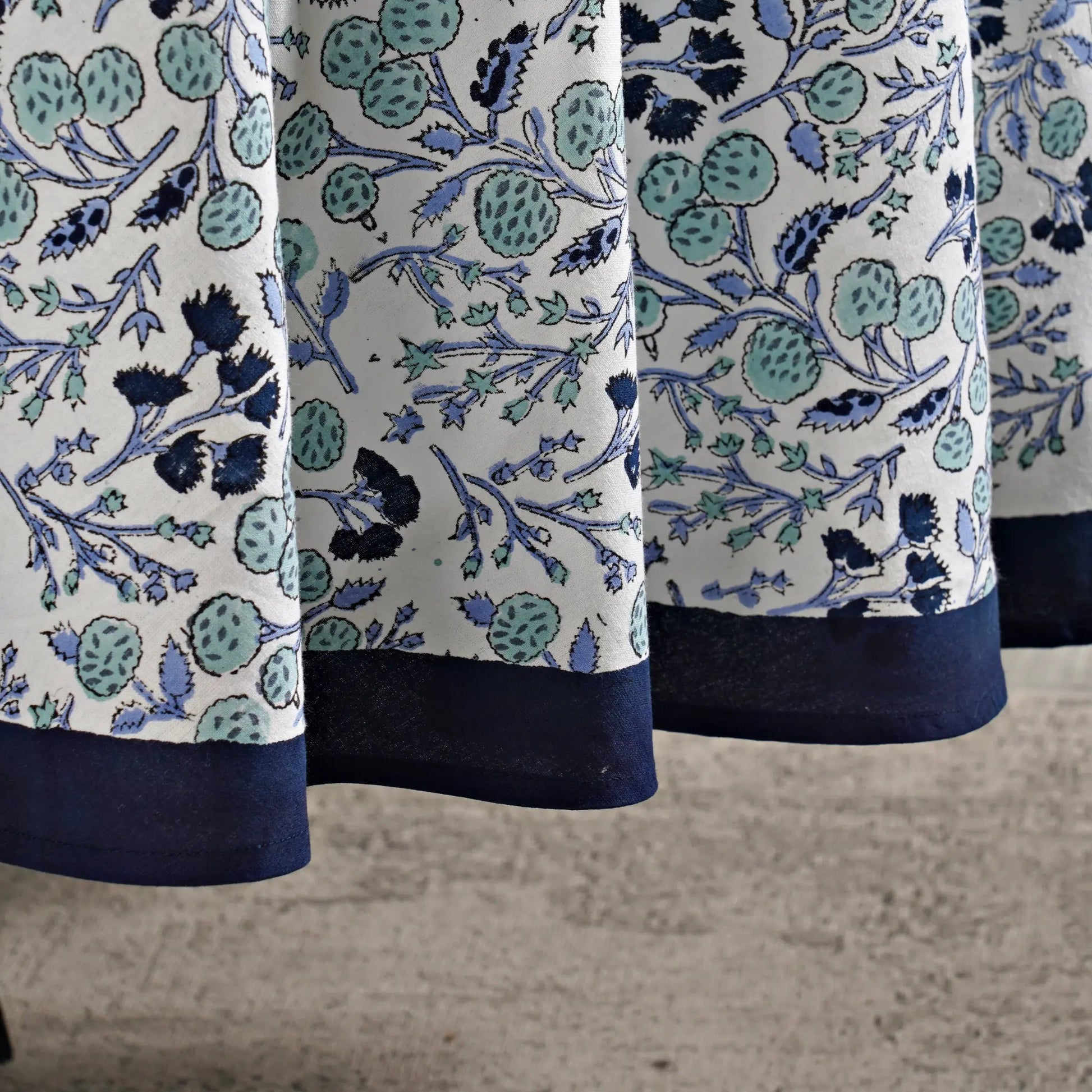 Close-up of a fabric with blue and green floral pattern on a white background