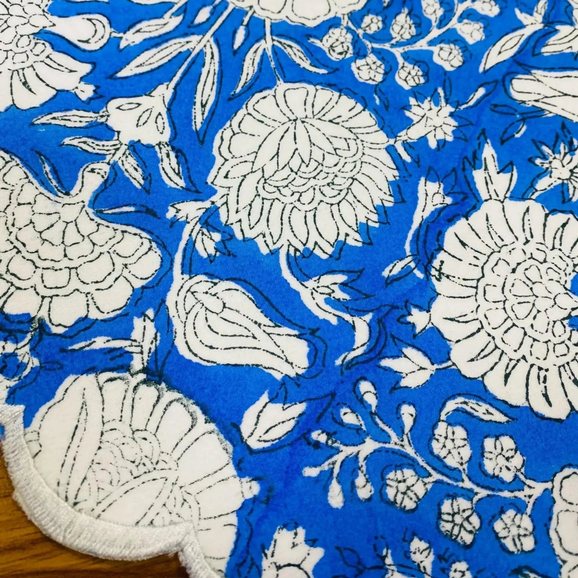 Blue fabric with white floral patterns on a wooden surface