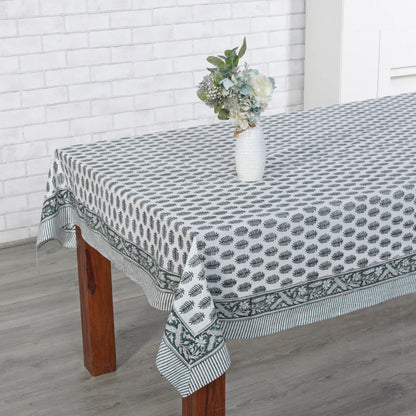 Tablecloth with a geometric pattern on a wooden table against a white brick wall.